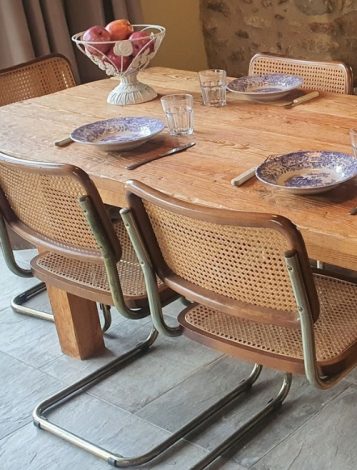 Mesa de comedor rústica de madera maciza con sillas de diseño clásico en Barcelona