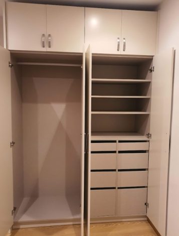 Armario empotrado a medida con estantes, cajoneras y puertas abatibles en Barcelona
